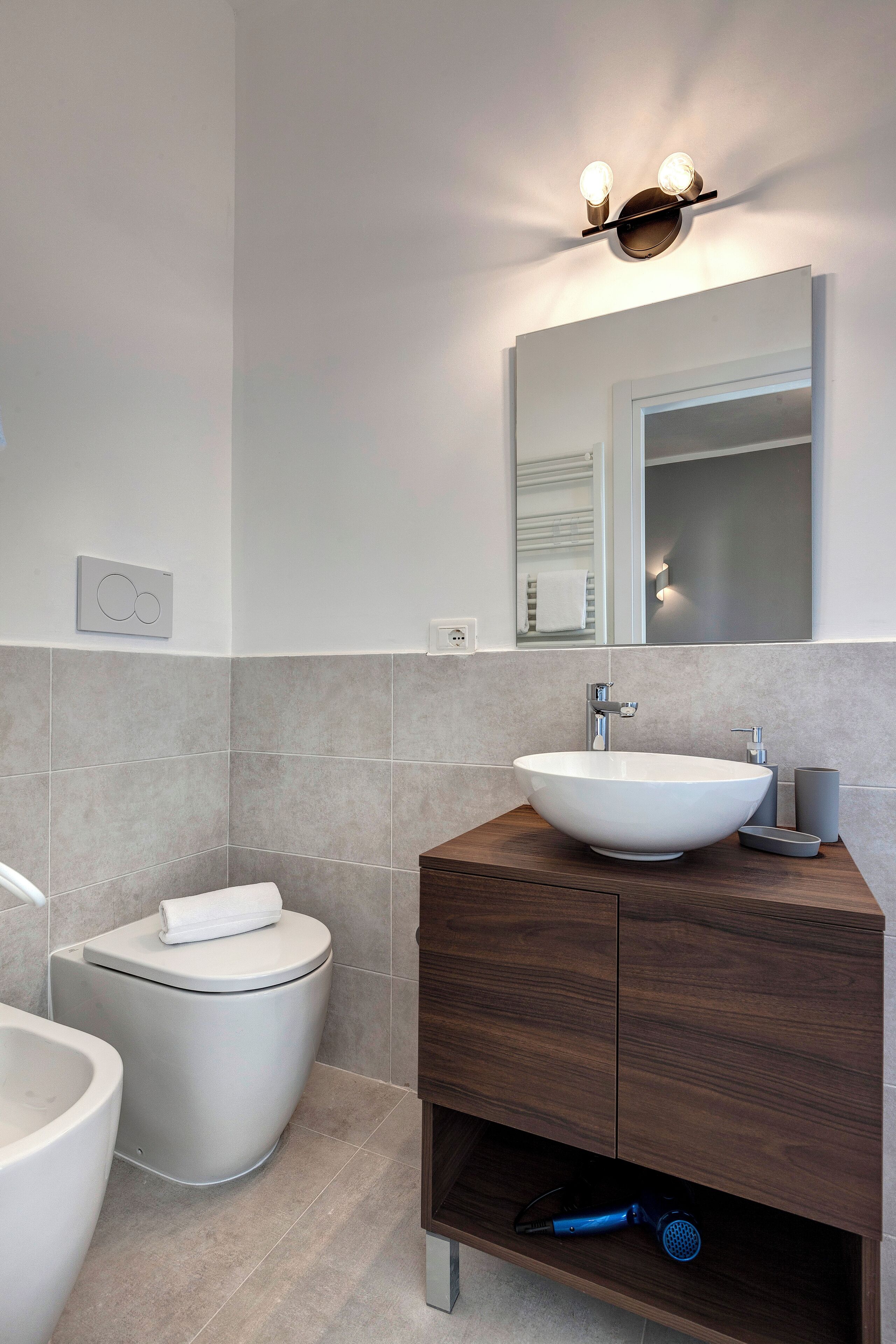 Ein modernes Badezimmer mit Waschbecken, Ablagefläche und Toilette in Weiß.
