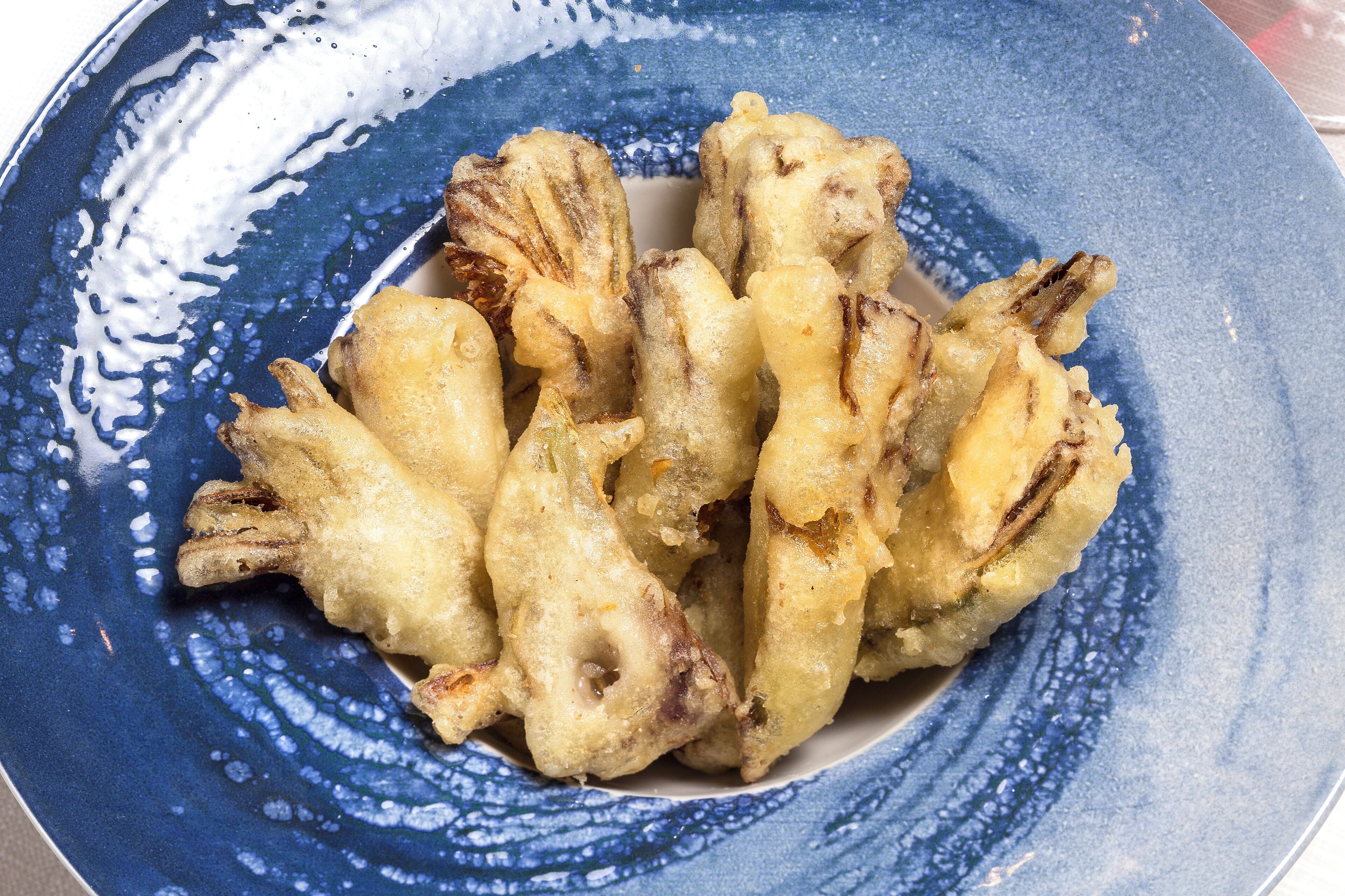 A blue ceramic plate with fried food items.