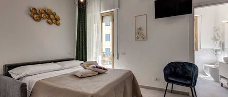 A modern bedroom with a bed, a chair, and a TV on the wall.