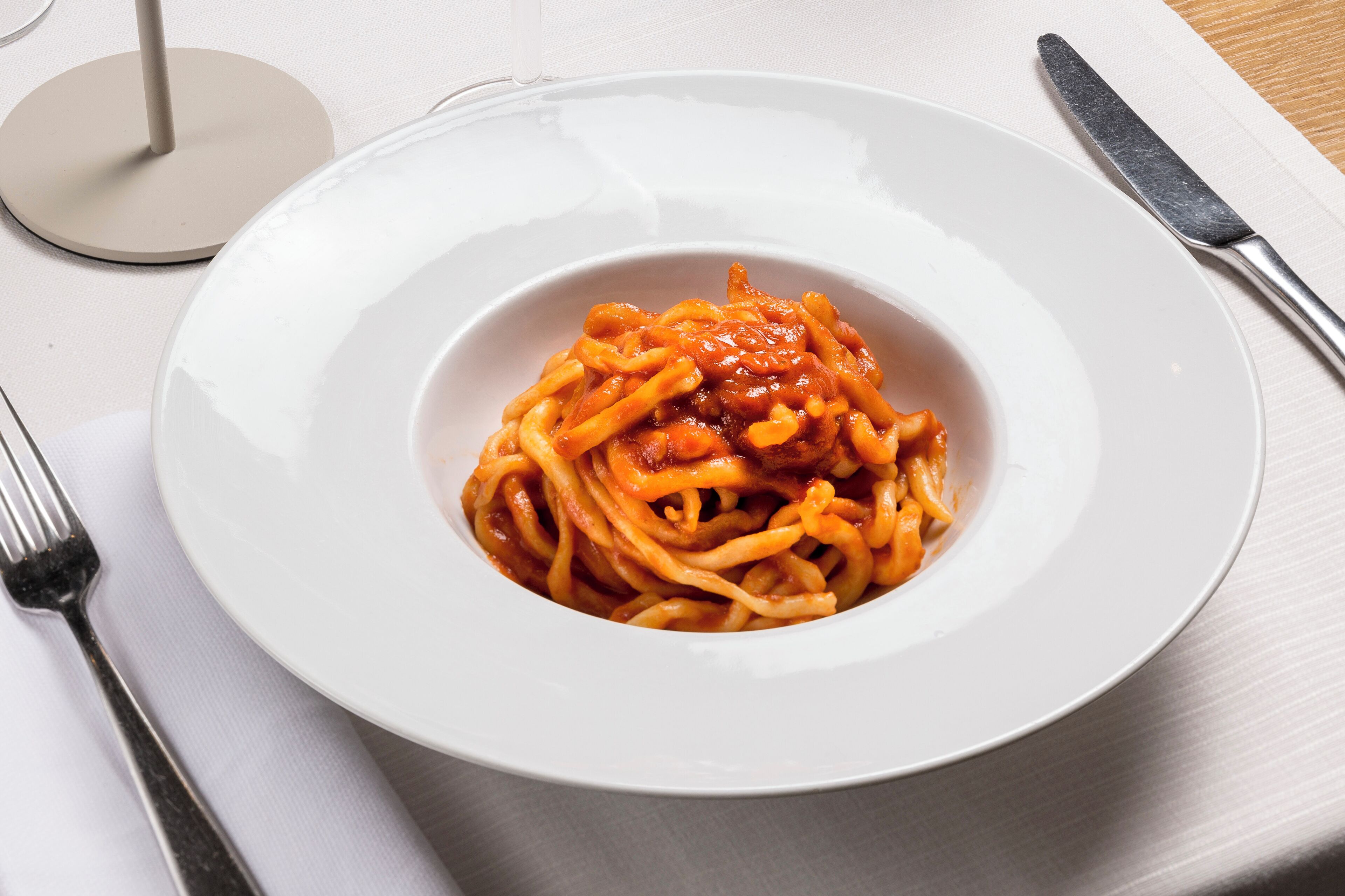 Une assiette blanche contenant des spaghettis et de la sauce tomate.