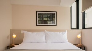 A neatly made bed with white linens, two bedside lamps, and a framed window above. - w Cozy Bright 2BR Stay in Barranco (Lima)