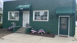 A green building with a sign reading "mint 2015". - Mid-Century Modern Broad Ripple Stay with Style, Comfort & Local Color (Indianapolis)