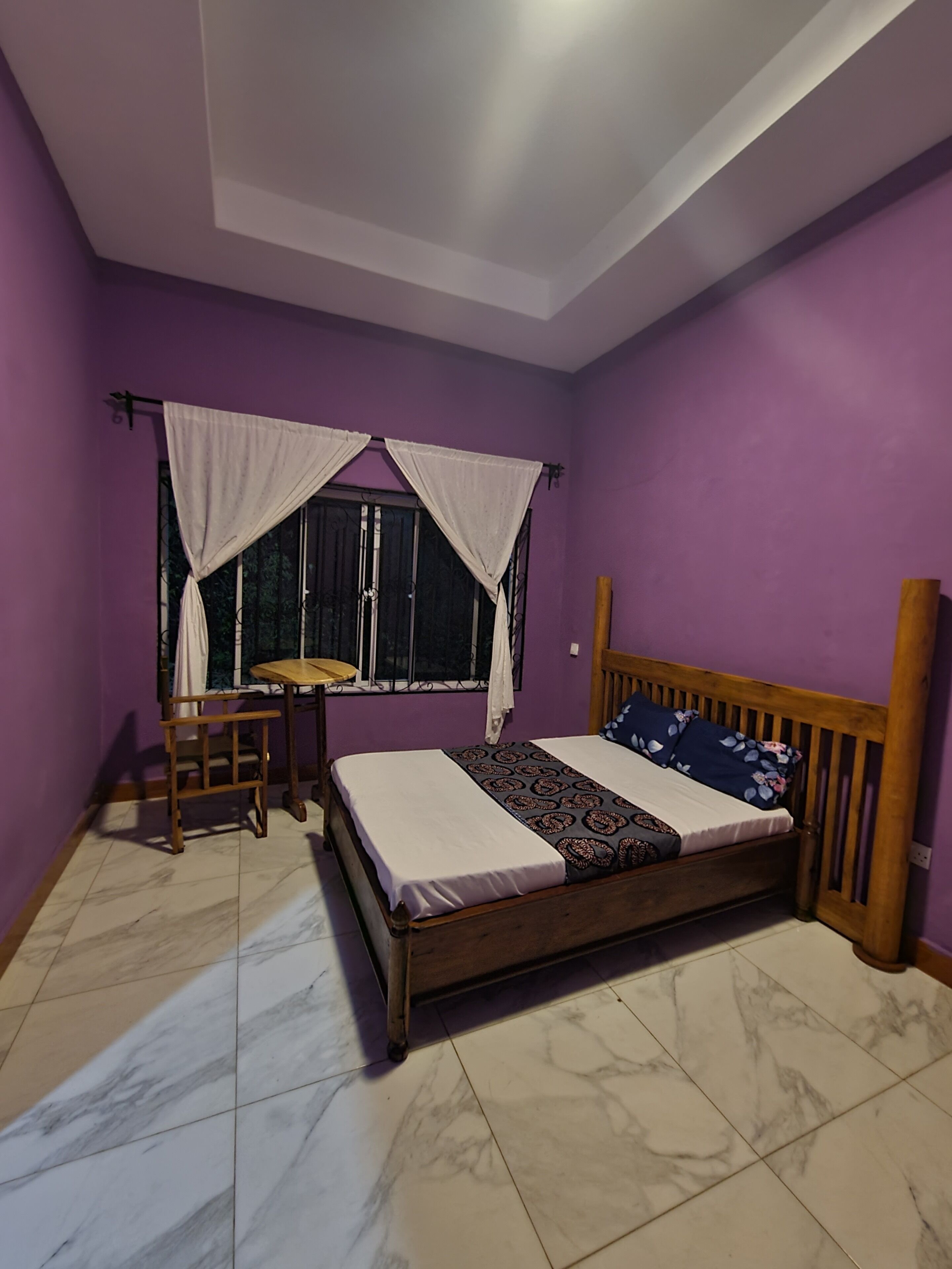 A bedroom with a bed, a desk, and a chair.