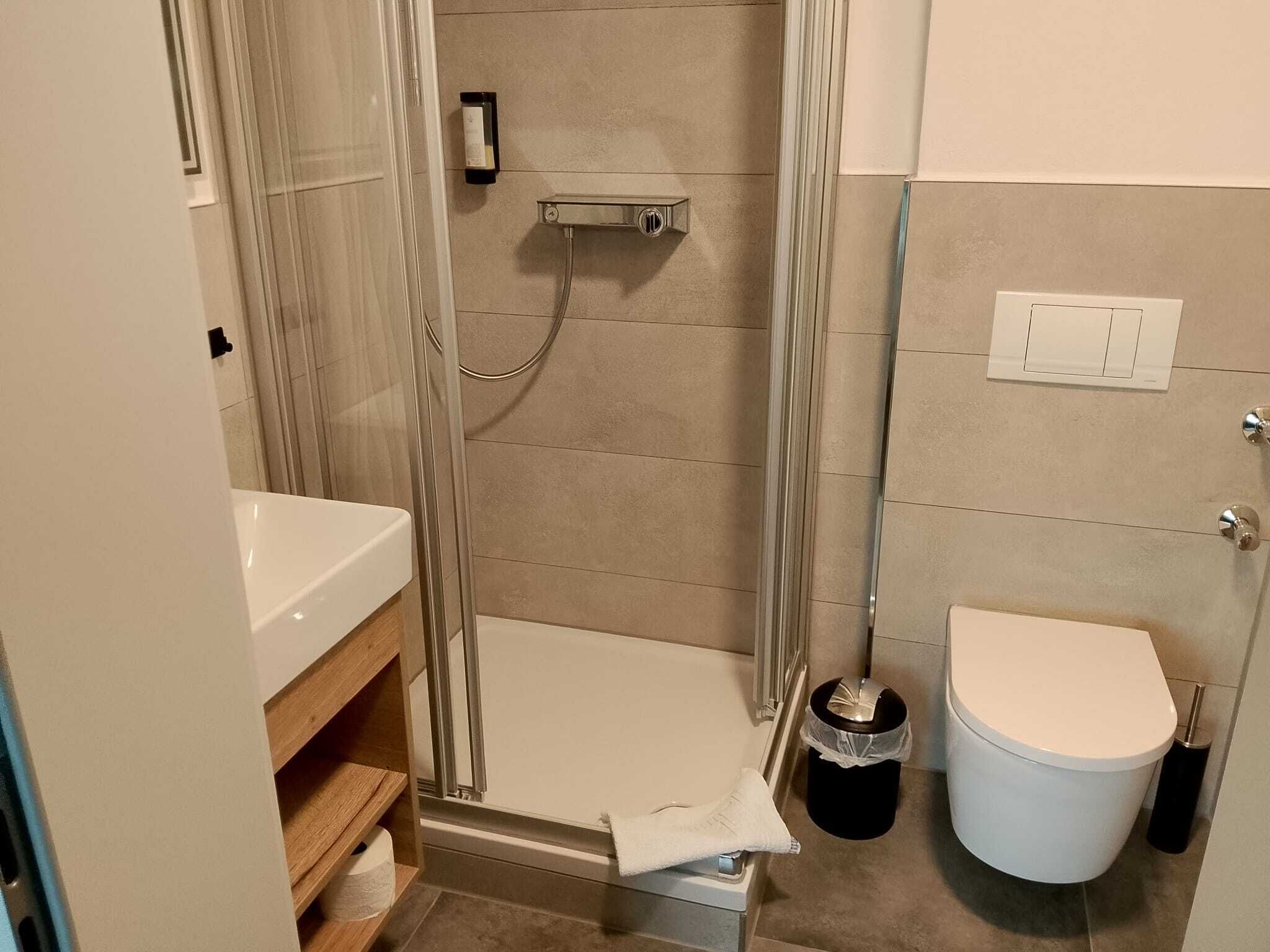 A bathroom with a shower, toilet, and sink.