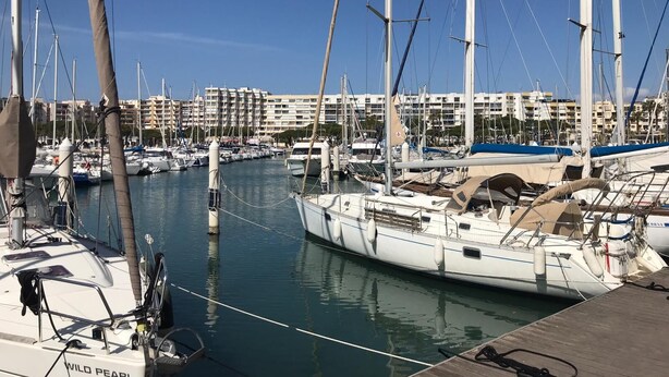 A marina with multiple sailboats docked, a wooden dock, and buildings in the background. - Studio on the port of Carnon with patio, 5mn from the beach, ideal for 3 people (Mauguio)