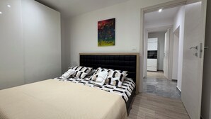 Una camera da letto moderna con un letto grande, una testiera e un quadro appeso al muro.