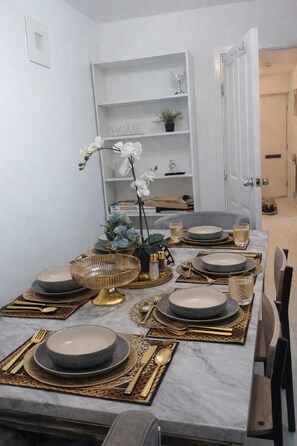A dining table set with plates, cutlery, and decorative items. - Cosy 5 bedroom, 3 bathroom next to Harrow Museum (Harrow)