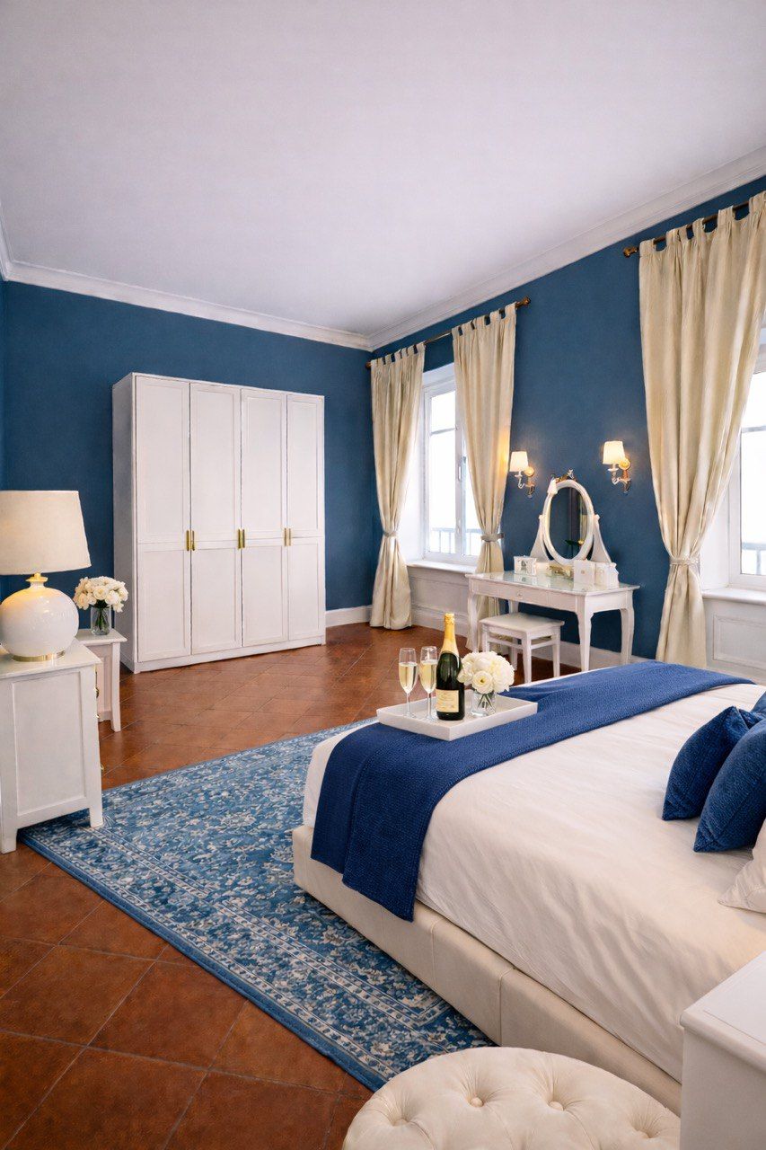 A bedroom with a bed, a dresser, a vanity, and a wardrobe.
