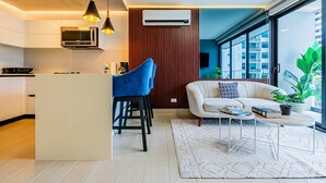 A modern kitchen with a central island, bar stools, a sofa, and a coffee table.