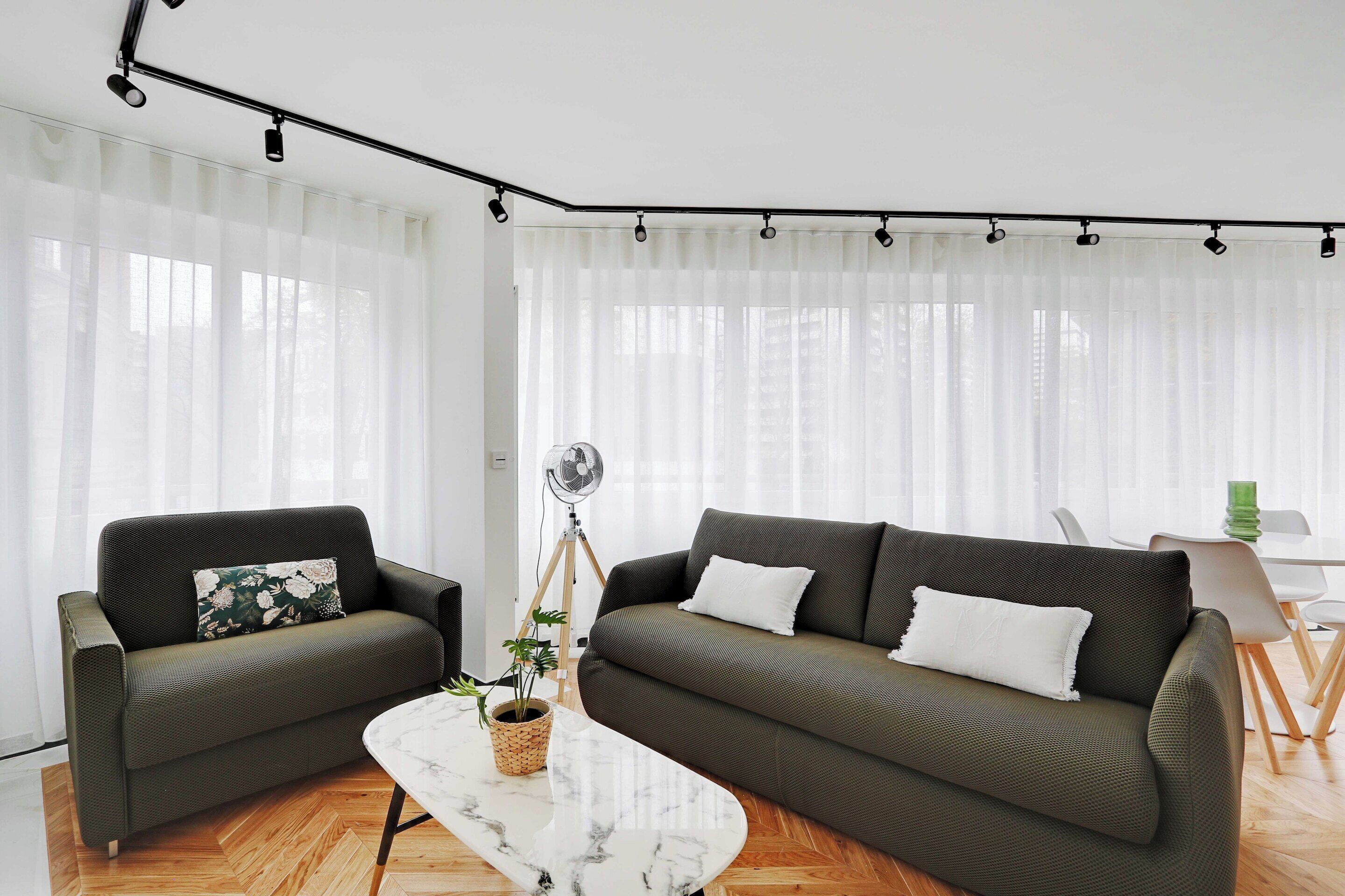 Un salon moderne avec deux canapés, une table basse et un lampadaire.