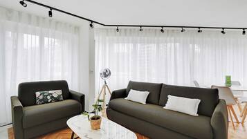 Un salon moderne avec deux canapés, une table basse et un lampadaire.