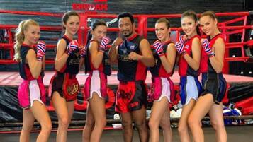 A group of cheerleaders in a gymnasium with boxing rings and a banner reading "KRODA".