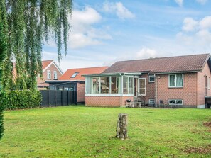A brick house with a covered porch and a lawn. - 6 Person Holiday Home in Ansager (Ansager)