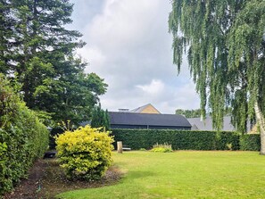 A residential property with a well-maintained lawn, a variety of trees, and a house with a dark roof. - 6 Person Holiday Home in Ansager (Ansager)