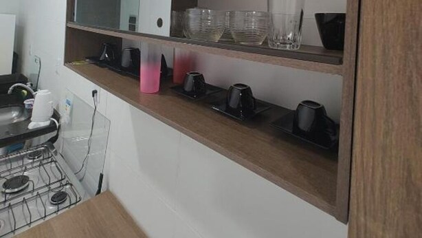 Een keuken met een houten plank, een spiegel en diverse keukengerei.