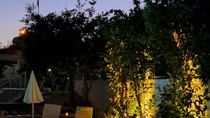 Ein Poolbereich mit Liegestühlen und einem kleinen Sonnenschirm.
