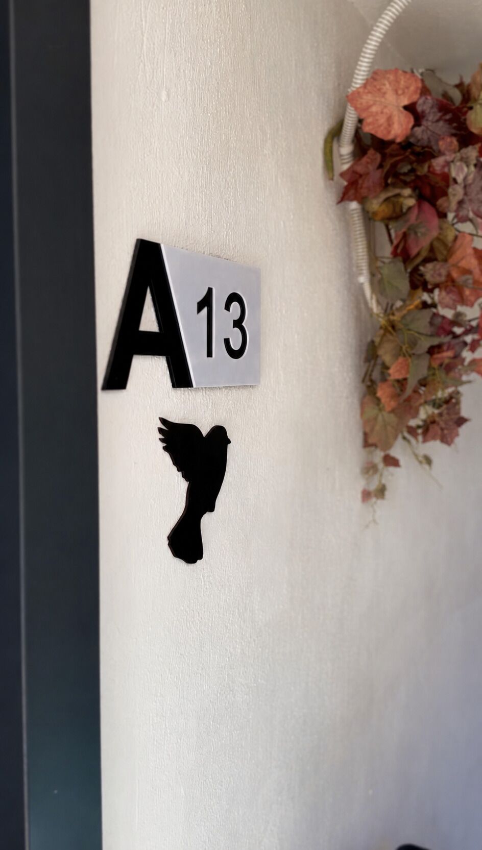 A wall with a sign reading 'A 13' and a silhouette of a bird.