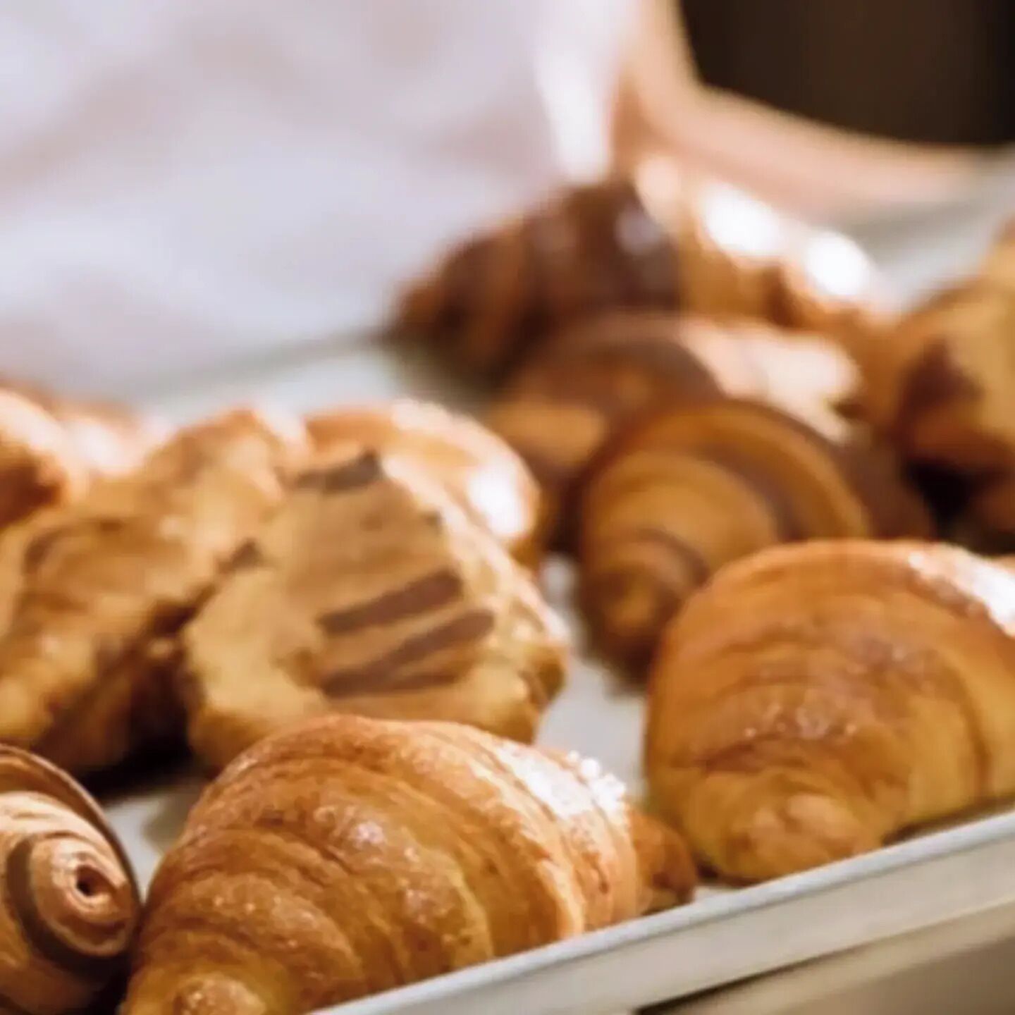 A tray of assorted pastries, including croissants and other baked goods.