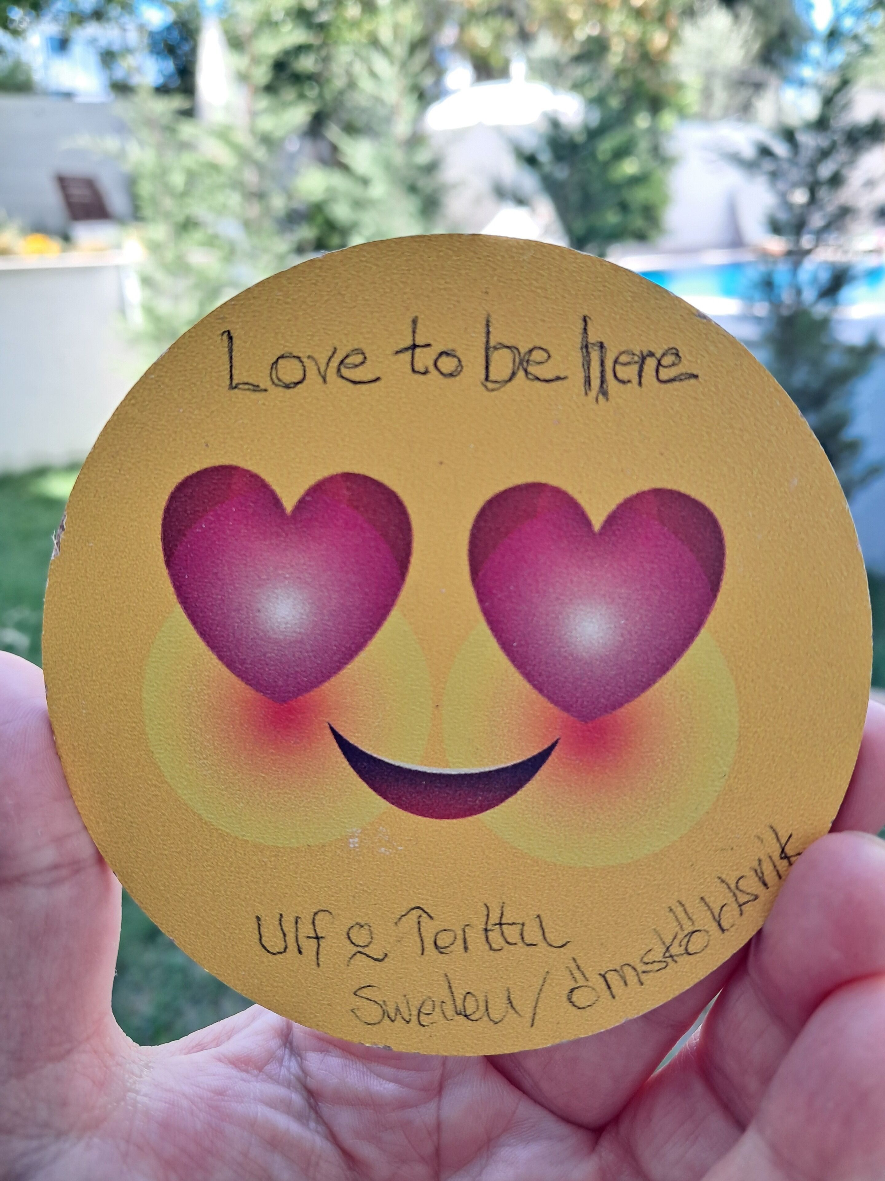 Ein runder Gegenstand mit dem Schriftzug 'Love to be here' und zwei Herzchen-Emojis.