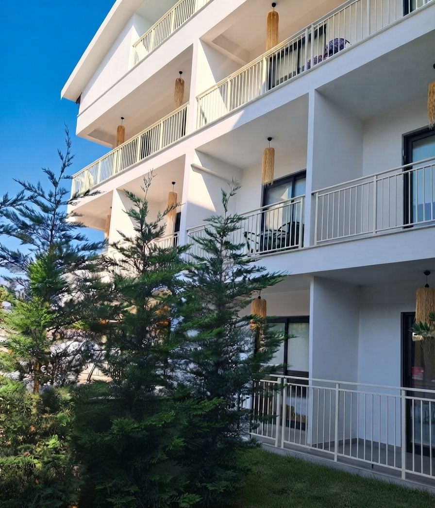 A multi-story building with balconies, large windows, and hanging light fixtures.