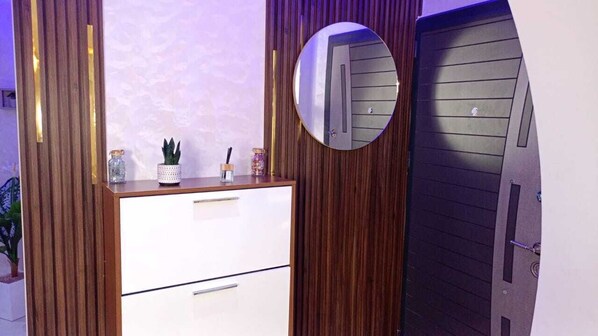 A room with a wooden panel wall, a white dresser with drawers, a mirror, and a door with a handle. - Rent new apartment in Agadir (Agadir)