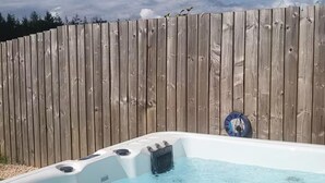 Ett bubbelbad med ett trästaket i bakgrunden.