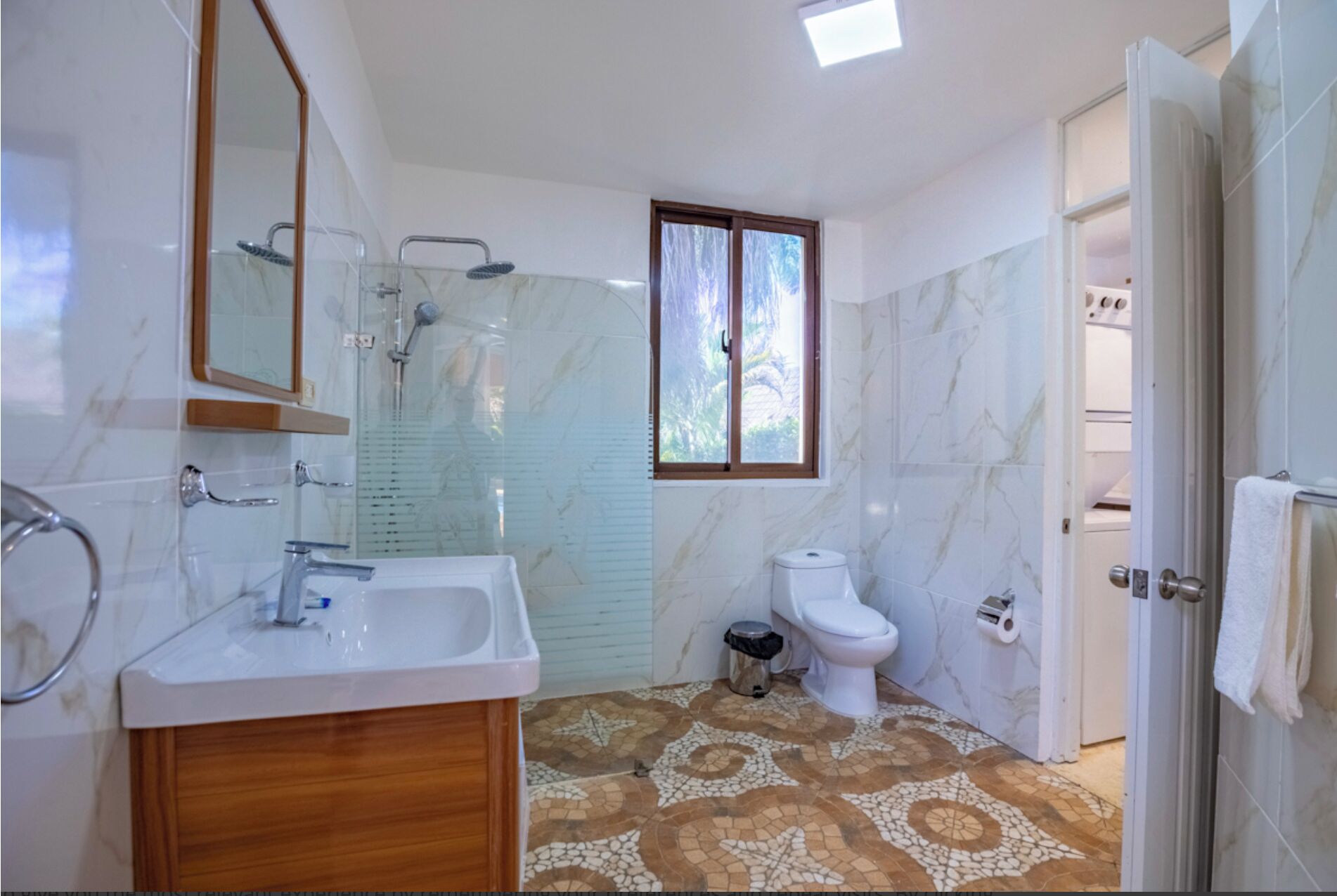 Une salle de bain avec douche, toilettes et lavabo.