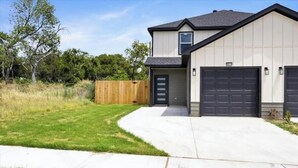 A two-story house with a garage, a front door, and a driveway. - Homely Haven (Fort Worth)