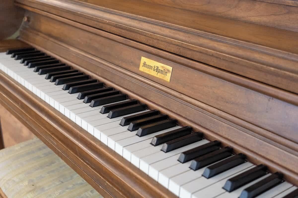 En närbild på ett piano med en etikett där det står ”Mason & Hamlin”.