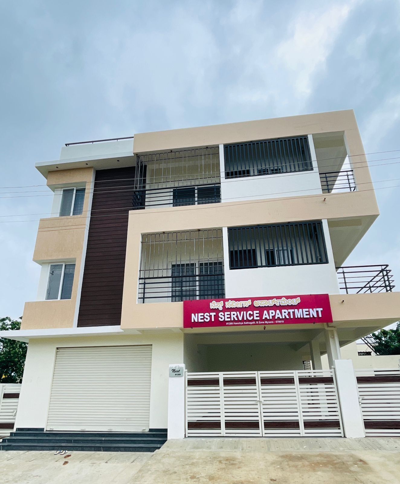 A multi-story building with a sign indicating it is a 'NEST SERVICE APARTMENT.'