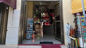 The entrance of Hotel San Miguel, Playa del Carmen Q. Roo, with a visible signboard, a mannequin displaying a garment, and a rack of sunglasses outside. - Hotel San Miguel Playa del Carmen (Playa del Carmen)