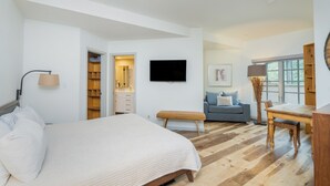 A bedroom with a bed, a desk, a chair, a TV, a sofa, and a window. - Westermere 211 - The Pinecone (Mountain Village)