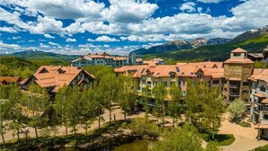 A resort with multiple buildings, a lake, and mountains in the background. - Westermere 211 - The Pinecone (Mountain Village)