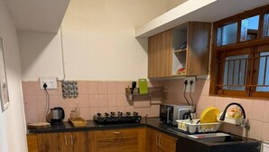 Une cuisine avec des meubles en bois, une cuisinière à gaz, un four à micro-ondes et un évier.