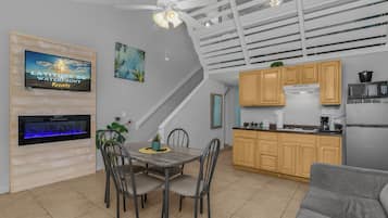 A compact kitchen with wooden cabinets, a microwave, and a refrigerator.