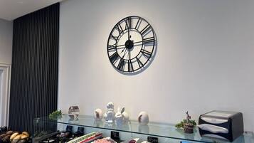 Un bufé de desayuno con diversas opciones de comida, un reloj en la pared y un diseño de interiores moderno.
