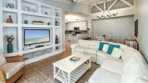 A modern living room with a white sofa, a flat-screen TV, and a ceiling fan. - Reserve.....Reserve Way (Naples)