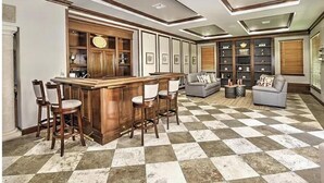 A spacious living area with a checkered floor, a bar with stools, and a sofa. - Reserve.....Reserve Way (Naples)