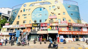 Un immeuble à plusieurs étages dont le rez-de-chaussée abrite divers commerces, notamment un hôtel et un restaurant.