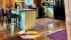 Una cocina amplia con vigas de madera, una isla grande y un refrigerador.