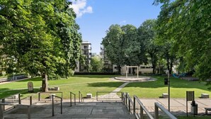 A park with a circular fountain, a playground, and a building in the background. - Cozy & Central studio in the royal heart of Oslo (Oslo)
