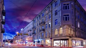 A multi-story building with a row of shops on the ground floor, featuring large windows and a classic architectural style. - Cozy & Central studio in the royal heart of Oslo (Oslo)