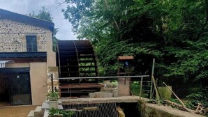 Un bâtiment doté d’une façade en pierre et agrémenté d’un élément décoratif aquatique à l’avant.