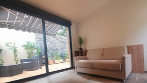 Um apartamento tipo estúdio com porta de vidro deslizante que dá para um pátio.