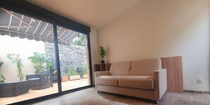 A studio apartment with a sliding glass door leading to a patio area. - Moulin de la Paille (Veyre-Monton)