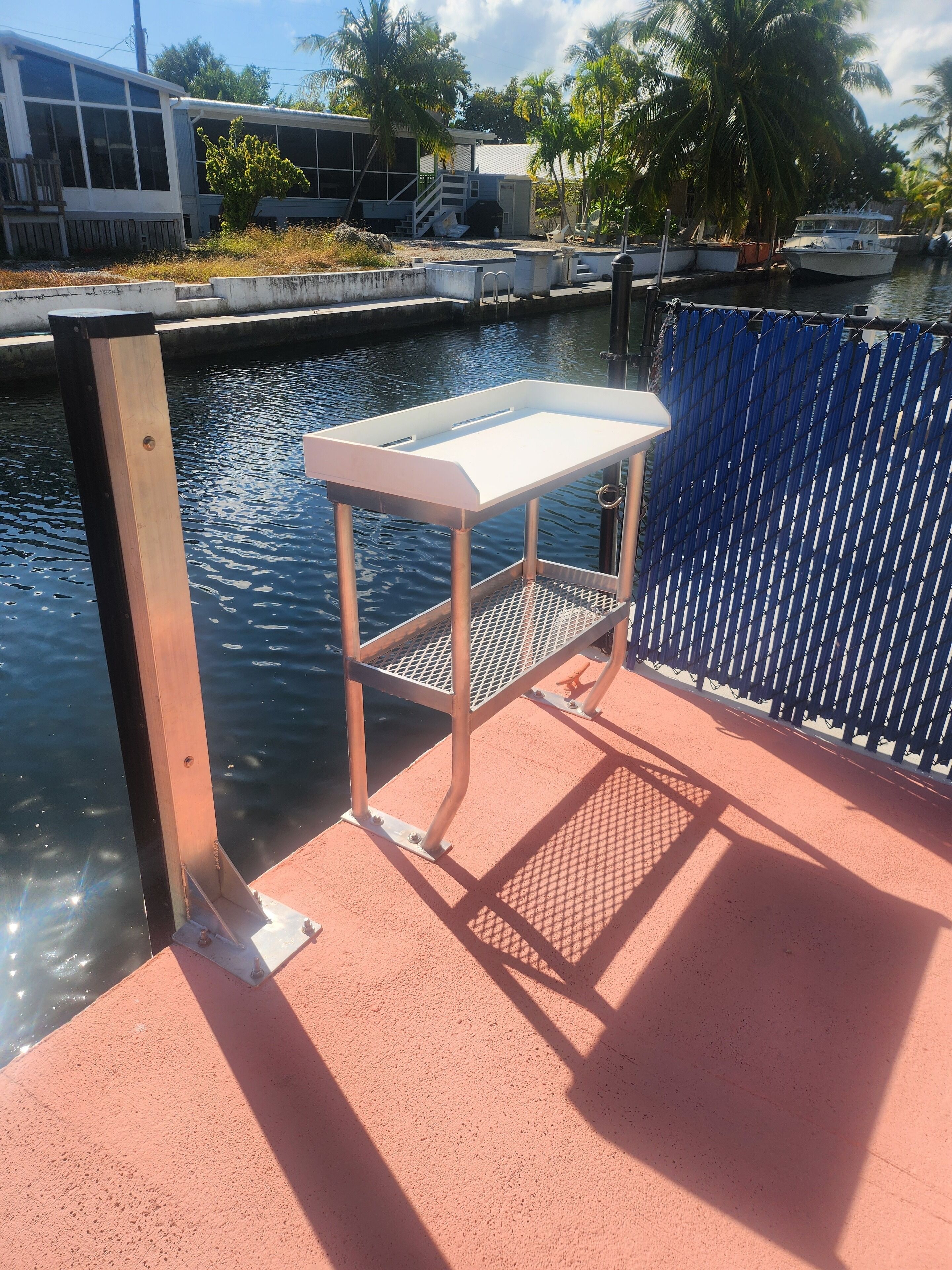 A dock with a metal table and a railing.
