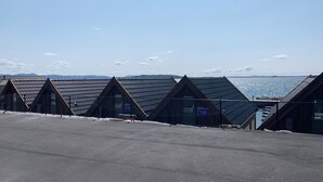 Gebäude mit dreieckigen Dächern und Blick auf das Meer.