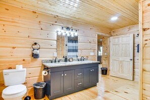 A wooden cabin bathroom with a sink, mirror, and toilet. - River Escape River Front Cabin (Tellico Plains)