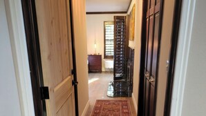 A hallway with a wooden floor, a patterned rug, and a door with a black frame. - High-End Private Suite with Deck & Mountain Views in Prime Marin County Location (Novato)