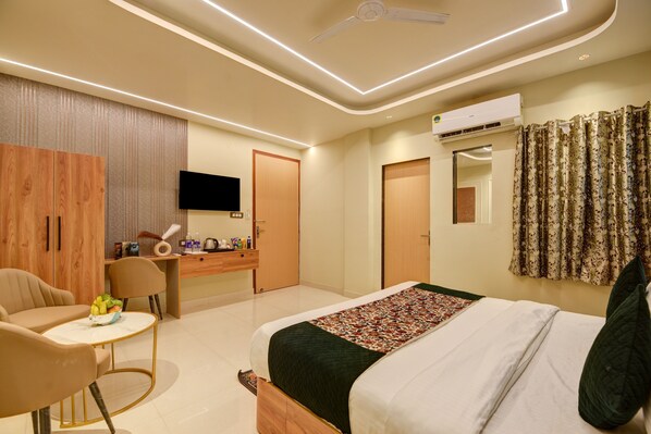 A modern hotel room with a bed, a desk, a chair, and a television. - HOTEL AERO HOMESTAY (New Delhi)